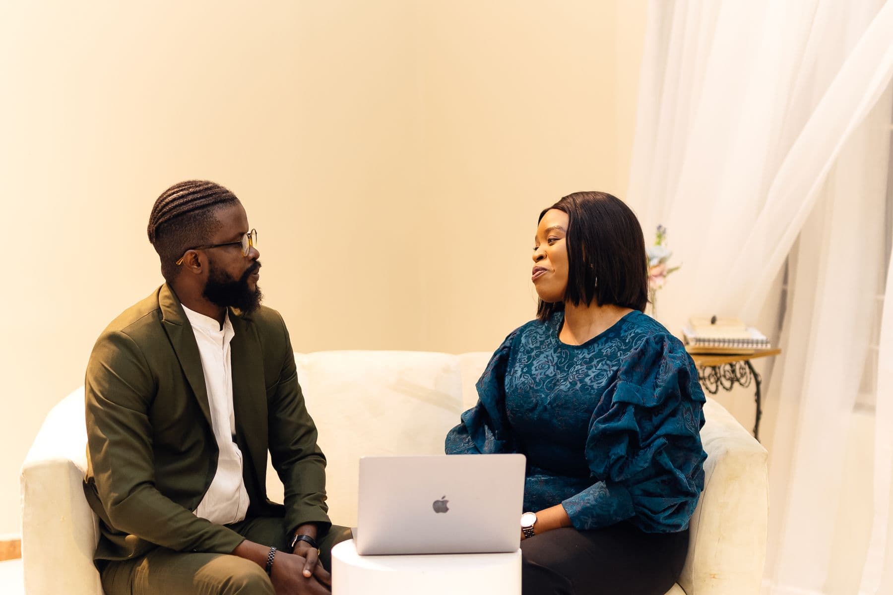 Two African professionals discuss an advisory engagement in a workspace.